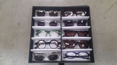 many pairs of glasses in a box on the floor