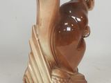 two figurines of a squirrel on a wooden base