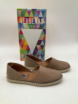 Les chaussures sont posées sur la table, à côté d'une boîte de verveines.