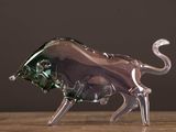 une figurine en verre représentant un taureau, posée sur une table