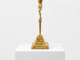 a gold statue of jesus on a pedestal with a white background