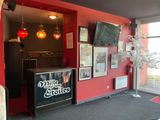 a red wall with a sign and a television in the corner