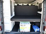 the back of a white van with a black seat and a box in the back