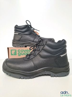 un gros plan d'une paire de chaussures noires posées sur une surface blanche