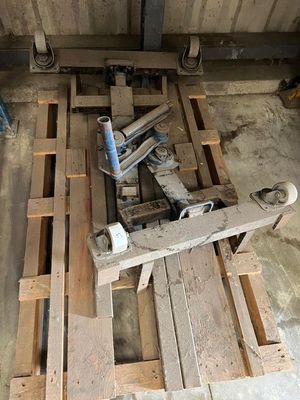 une photo montrant une pile de palettes en bois et une perceuse