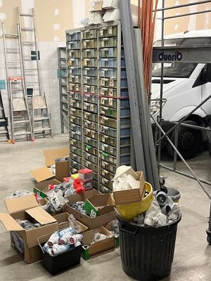 de nombreux cartons de déchets dans un entrepôt, avec un camion en arrière-plan