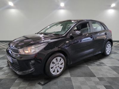 a black car is parked on a checkered floor in a garage