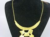 un gros plan d'un collier en or autour du cou d'un mannequin