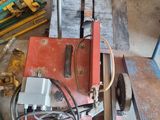 une machine posée au sol à côté d'un tas de matériel de chantier