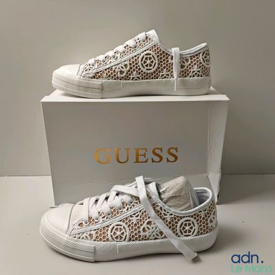 Baskets en dentelle blanche avec un logo doré sur le côté
