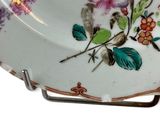 a plate with a floral design on it on a stand
