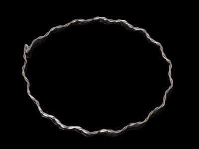 gros plan d'un bracelet en argent sur fond noir