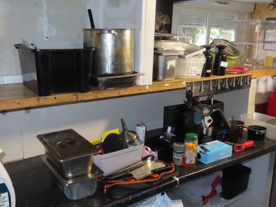 un plan de travail noir sur lequel sont posés des casseroles et des poêles