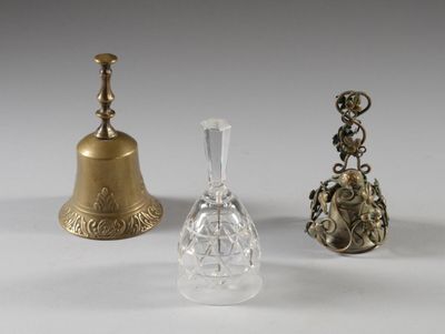 trois types différents d'objets en verre et en laiton posés sur une surface blanche