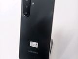 the back of a black samsung galaxy s10e phone on a white surface