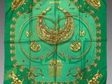 foulard en soie vert et or orné d'un motif représentant un oiseau et d'autres éléments