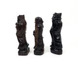 three carved figurines of a woman and a man on a white background