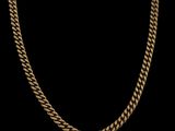 un collier à chaîne en or avec un maillon plat sur fond noir