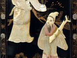 two asian figurines on display in a display case