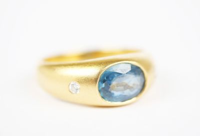 a close up of a gold ring with a blue topaz stone