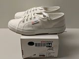 a pair of white shoes sitting on top of a box