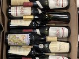 bottles of wine are in a cardboard box on a tile floor