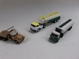 trois camions miniatures posés les uns à côté des autres sur une table
