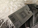 a tag on a jacket that is sitting on a bed