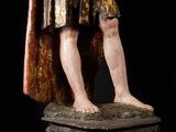 an antique statue of a man dressed in armor and holding a sword