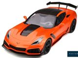 the orange sports car is parked on a white surface