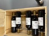 bottles of wine are in a wooden box on a table