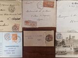 several old postcards and envelopes are on display on a table