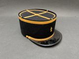 chapeau noir et doré orné d'une croix sur le dessus
