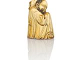an antique carved ivory figurine of a man with a beard