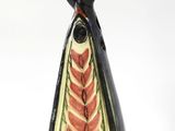 un petit vase noir et rouge surmonté d'un oiseau