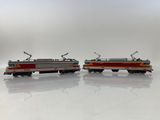 two toy trains sitting side by side on a white surface