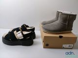 deux paires de chaussures noires et grises posées sur une boîte en carton