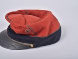 a red and black hat with a button on it