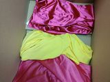 une boîte contenant trois t-shirts de couleurs différentes
