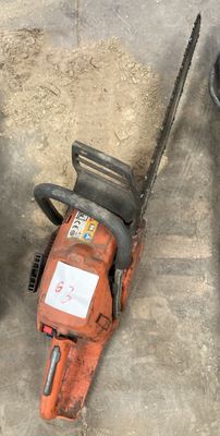 two chainsaws sitting next to each other on the ground