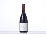 a bottle of red wine sitting on a table