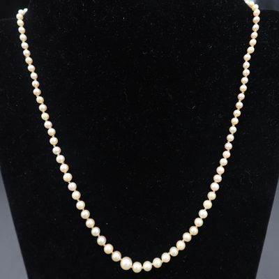 un collier de perles blanches sur un mannequin noir