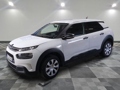 Le SUV Citrole blanc est garé dans une grande pièce.