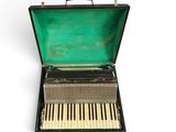 an open suitcase with a piano inside of it on a white surface