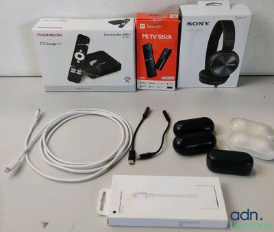 deux boîtes de casques audio et un chargeur posés sur une table