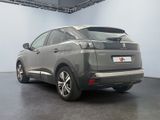 the rear end of a grey car parked in a garage