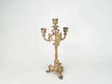 brass candelab with three candles on a white background