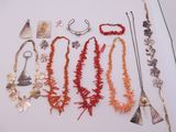 Plusieurs colliers et bracelets sont exposés sur un fond blanc