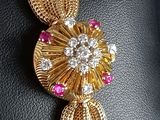 an image of a close up of a gold and pink broochle