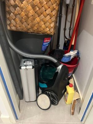 an image of a trash can and a vacuum in a closet